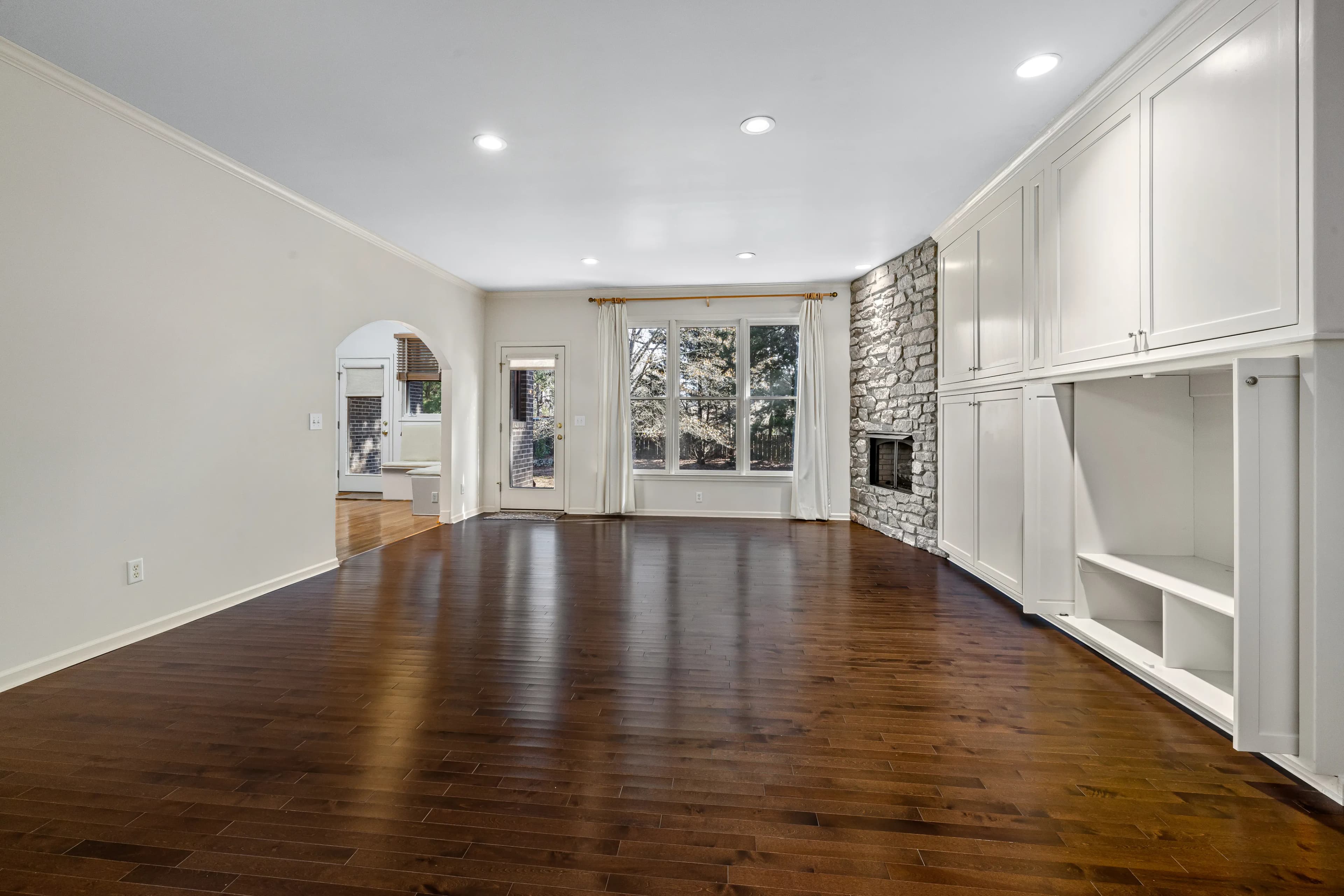 Living room with solid hardwood floor and stone fireplace